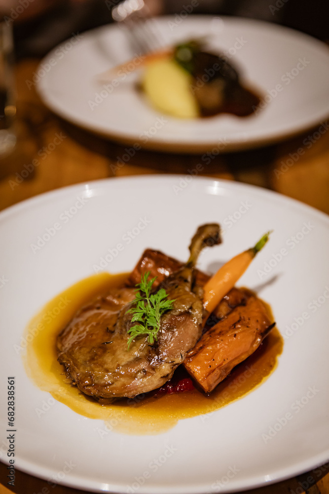 Confit Duck Leg Plated with Roasted Root Vegetables, Beetroot Pur�e, and Orange Jus, in Fine Dining Restaurant