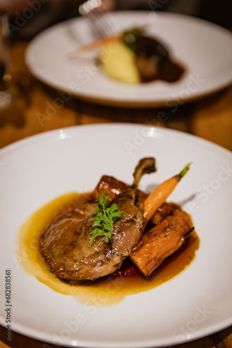 Confit Duck Leg Plated with Roasted Root Vegetables, Beetroot Pur�e, and Orange Jus, in Fine Dining Restaurant