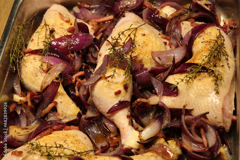 chicken legs covered with glazed red onions and figs in an oven tray