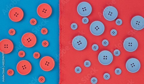 Coral and blue buttons of different sizes on a background of coral and blue fabric