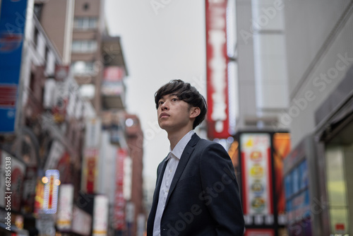 新橋の繁華街に立つ若いビジネスマン photo
