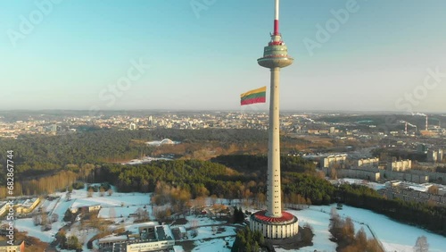 Giant tricolor Lithuanian flag waving on Vilnius television tower on the celebration of Restoration of the State Day in Vilnius. Aerial view. photo