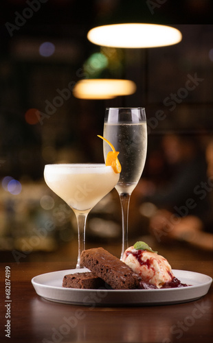 pairing sweet ice cream dessert with brownie and porn star martini cocktails and glass of dry sparkling wine blurred background photo