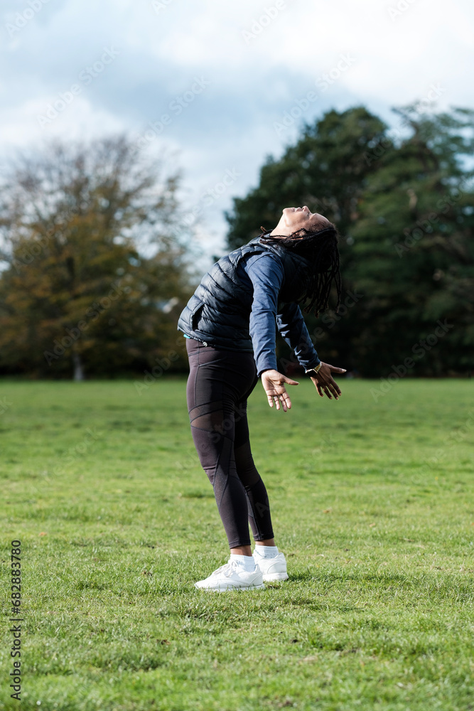 Fitness mature woman in a freedom pose in a park. Fitness mature woman in a freedom pose in a park.