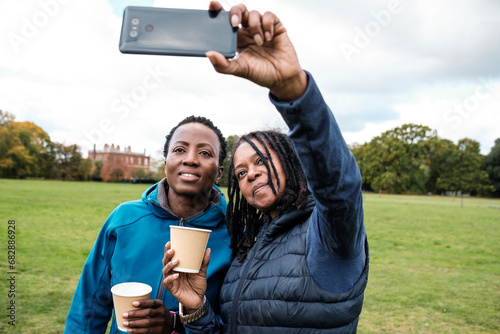 Fitness mature black women making selfie in a park.