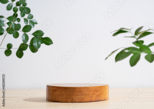 Fototapeta Naklejka Na Ścianę i Meble -  Wooden podium table top blurred green leaf plant on white empty space nature background.Beauty cosmetic natural product modern stage display.