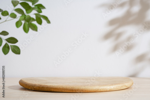 Wooden podium table top blurred green leaf plant on white empty space nature background.Beauty cosmetic natural product modern stage display.