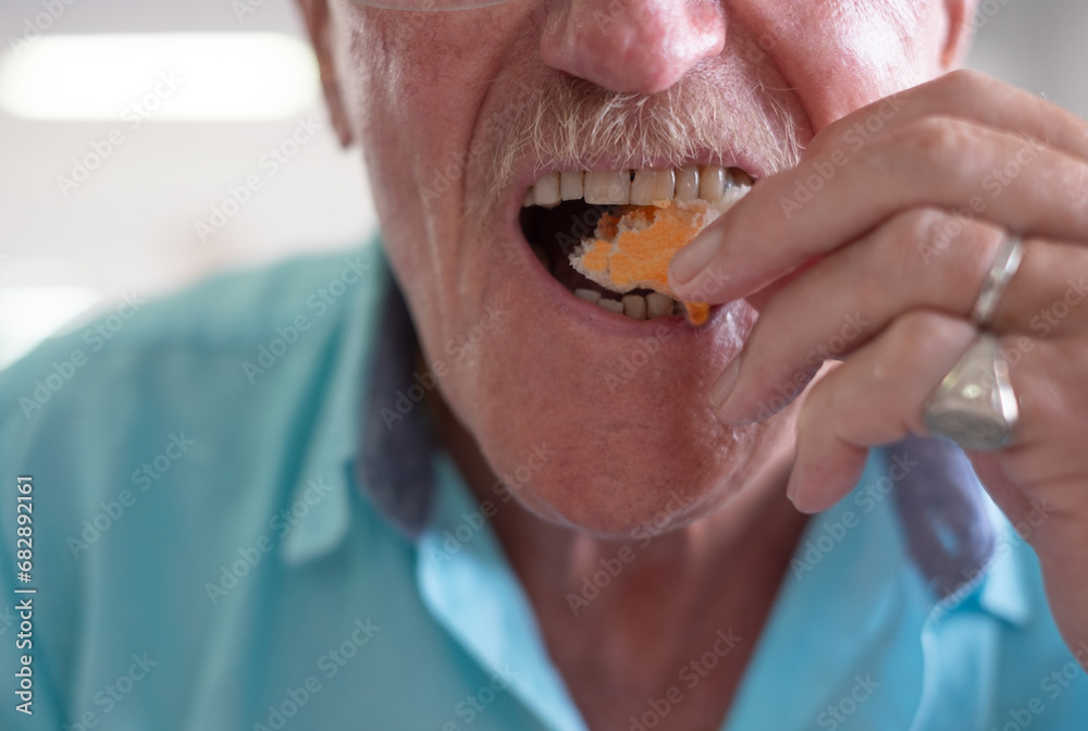 Close up on caucasian senior man mouth eating bread with spicy oil Close up on caucasian senior man mouth eating bread with spicy oil