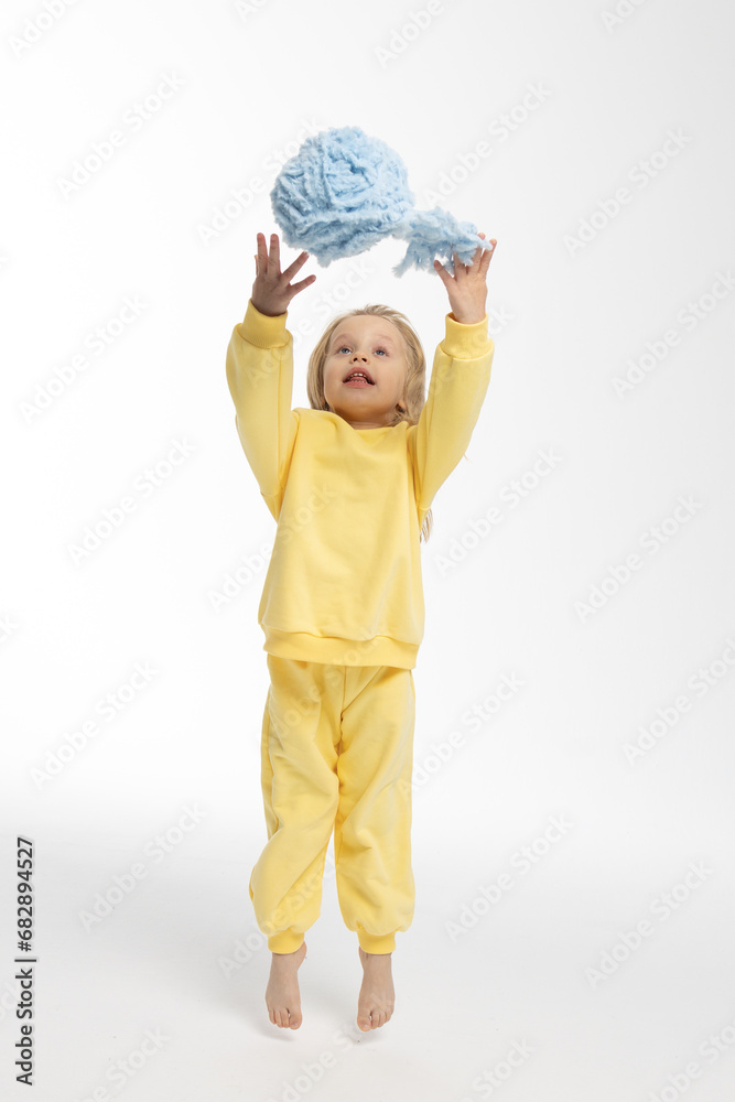 Portrait of beautiful cute little toddler girl. Child with funny face in yellow sweatshirt jumps. Pretty smile kid in studio on white background. High quality photo Portrait of beautiful cute little toddler girl. Child with funny face in yellow sweatshirt jumps. Pretty smile kid in studio on white background. High quality photo