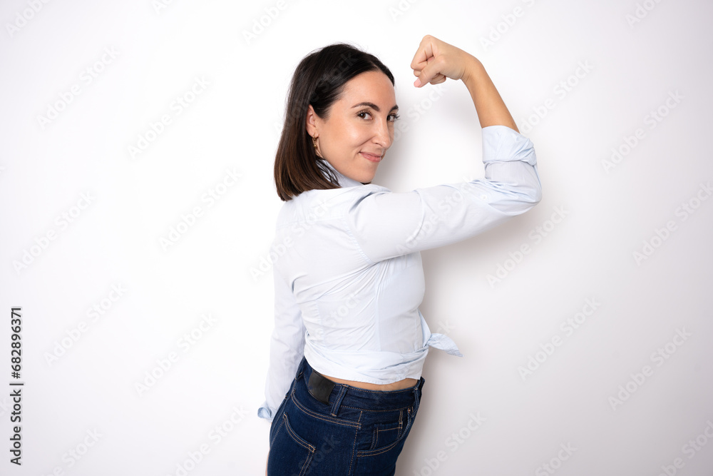 Beautiful young business woman over isolated background Strong person showing arm muscle, confident and proud of power Beautiful young business woman over isolated background Strong person showing arm muscle, confident and proud of power