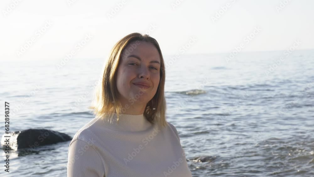 Portrait of a 40s woman near the seashore, smiling and looking at the camera. Close-up Portrait of a 40s woman near the seashore, smiling and looking at the camera. Close-up