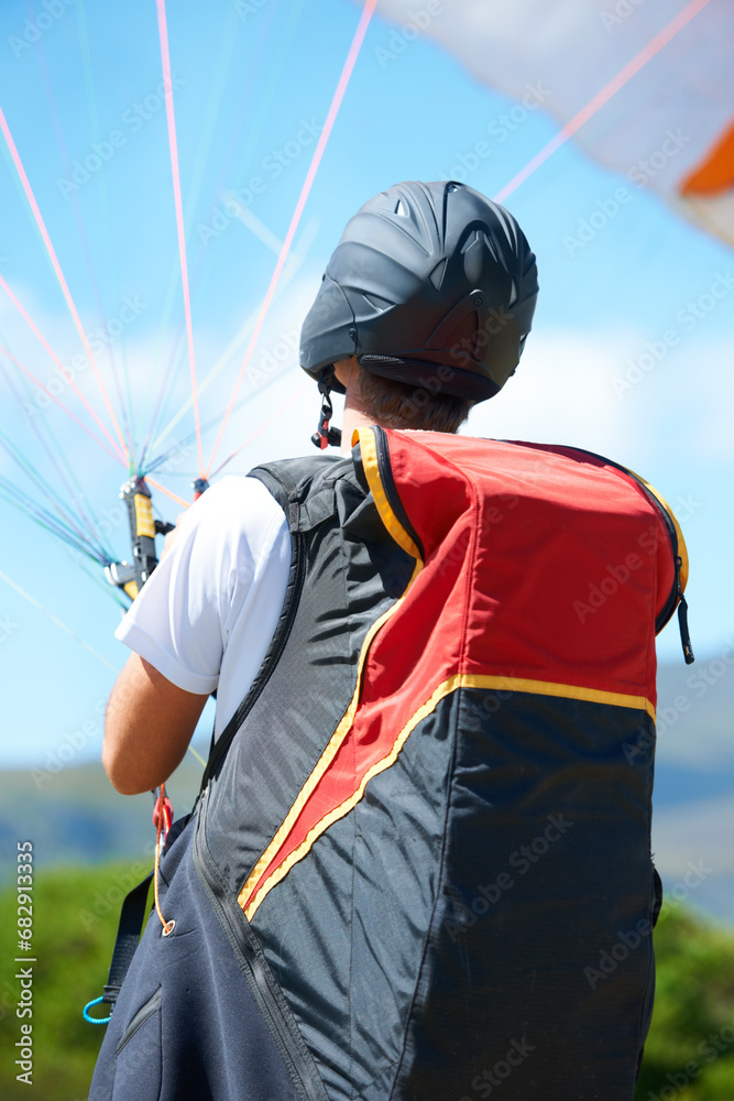 Man, parachute or paragliding launch in nature, exercise or healthy adventure for extreme sport. Person, strings or training for outdoor fitness for wellness, helmet or safety gear by blue sky Man, parachute or paragliding launch in nature, exercise or healthy adventure for extreme sport. Person, strings or training for outdoor fitness for wellness, helmet or safety gear by blue sky