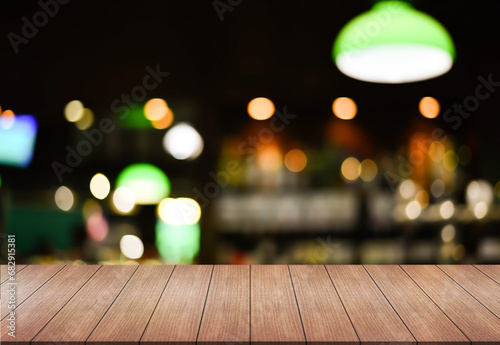 Empty wooden table top with lights bokeh on blur restaurant background.