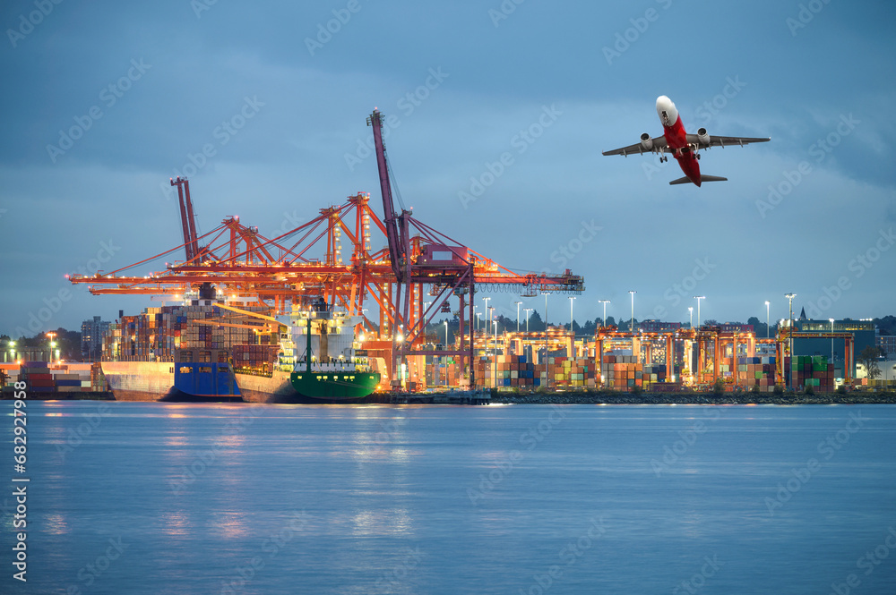Fototapeta premium International cargo ship with logistics and containers cargo illumination, gantry cranes and commercial airplane flying at habour