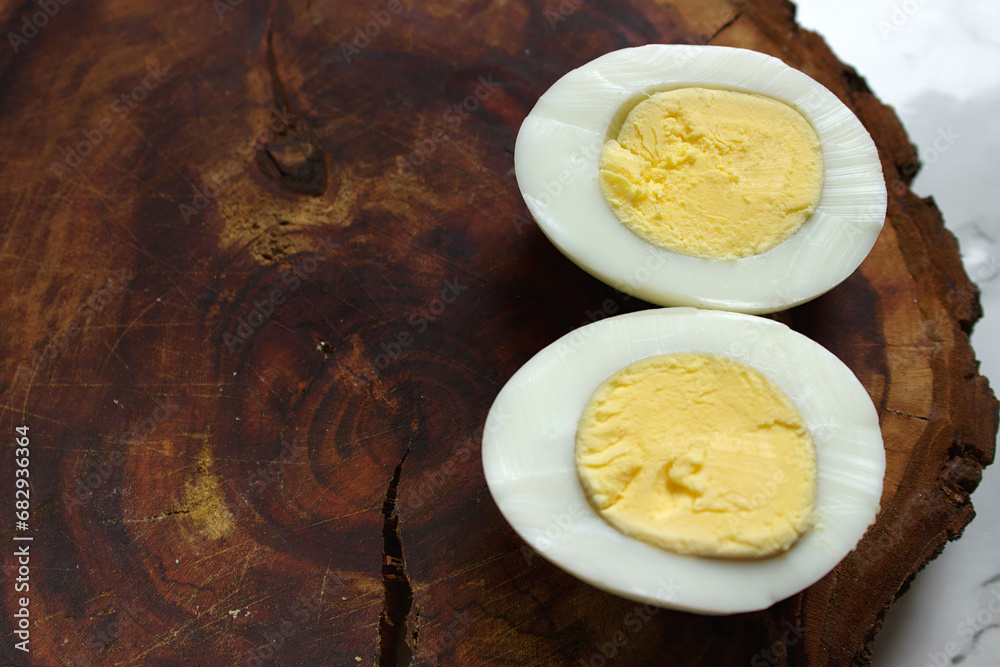 Boiled chicken egg on a wooden board on a marble background Boiled chicken egg on a wooden board on a marble background