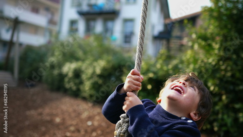 Excited Child in Close-Up, Gripping and Sliding on Wire Rope Between Trees