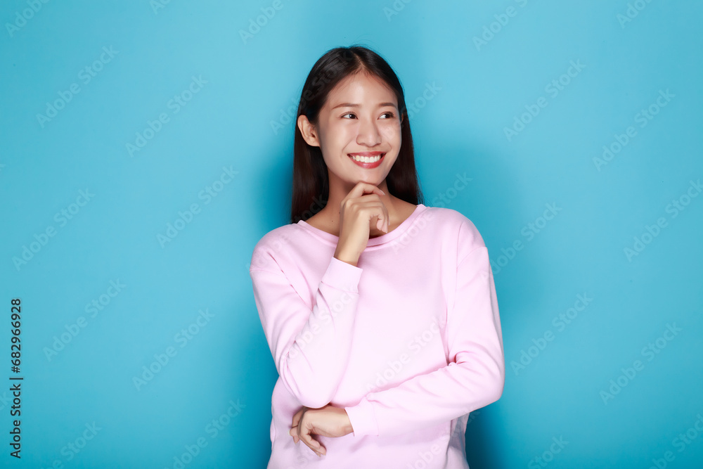 Pretty girl makes a thoughtful expression, Portrait of a beautiful young woman in a light blue background, happy and smile, posting in stand position. Pretty girl makes a thoughtful expression, Portrait of a beautiful young woman in a light blue background, happy and smile, posting in stand position.