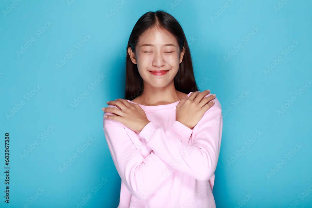 Portrait of a friendly young woman smiling happily, Portrait of a beautiful young woman in a light blue background, half body photo of nice positive lady crossed arms posing empty space ad isolated. Portrait of a friendly young woman smiling happily, Portrait of a beautiful young woman in a light blue background, half body photo of nice positive lady crossed arms posing empty space ad isolated.