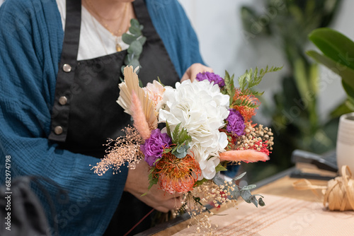 Anonymous person crafting a bouquet with flowers photo