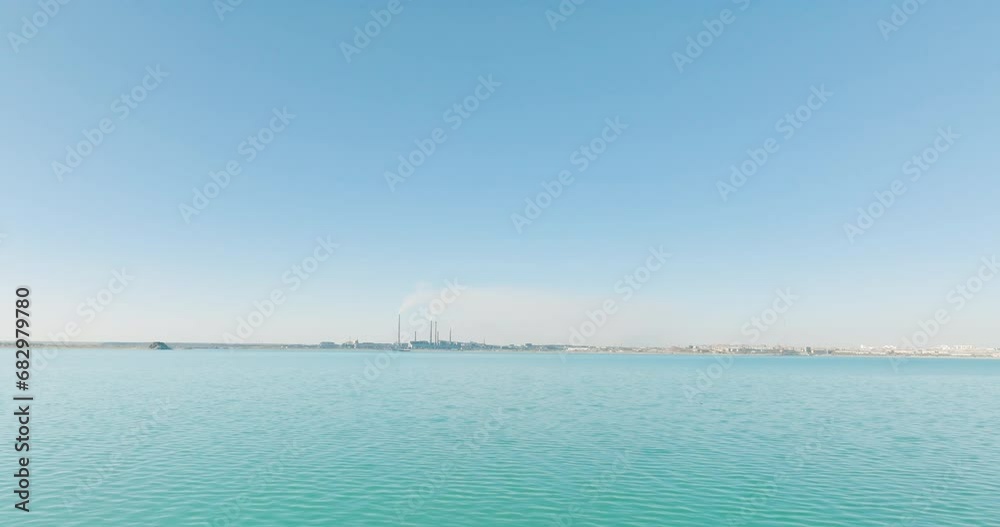 Metallurgy steel plant with smoke chimneys on lake coast in wild flat arid steppe. Aerial drone view above non-ferrous metallurgical factory at autumn sunny sunset with reflections on water. Metallurgy steel plant with smoke chimneys on lake coast in wild flat arid steppe. Aerial drone view above non-ferrous metallurgical factory at autumn sunny sunset with reflections on water.