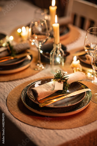 winter holidays, dinner party and celebration concept - close up of scandinavian christmas table serving with burning candles at home at night