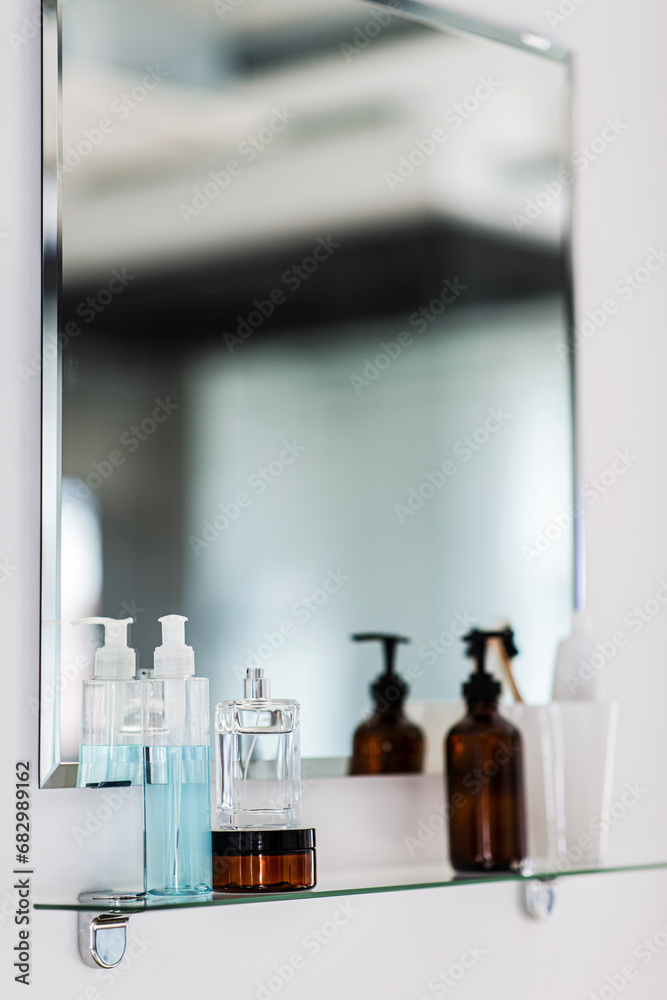 hygiene, beauty and daily routine concept - close up of lotion, perfume and moisturizer on mirror shelf in bathroom hygiene, beauty and daily routine concept - close up of lotion, perfume and moisturizer on mirror shelf in bathroom