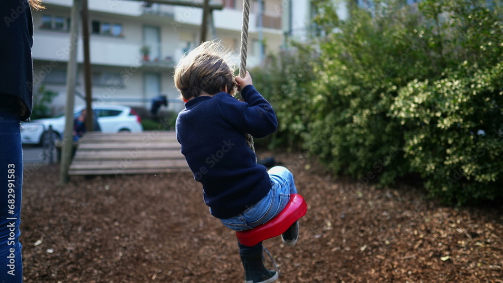 Joyful Small Boy Sliding Down Wire Rope Between Trees, Close-Up. Public playground park of child in nostalgic scene depiction Joyful Small Boy Sliding Down Wire Rope Between Trees, Close-Up. Public playground park of child in nostalgic scene depiction