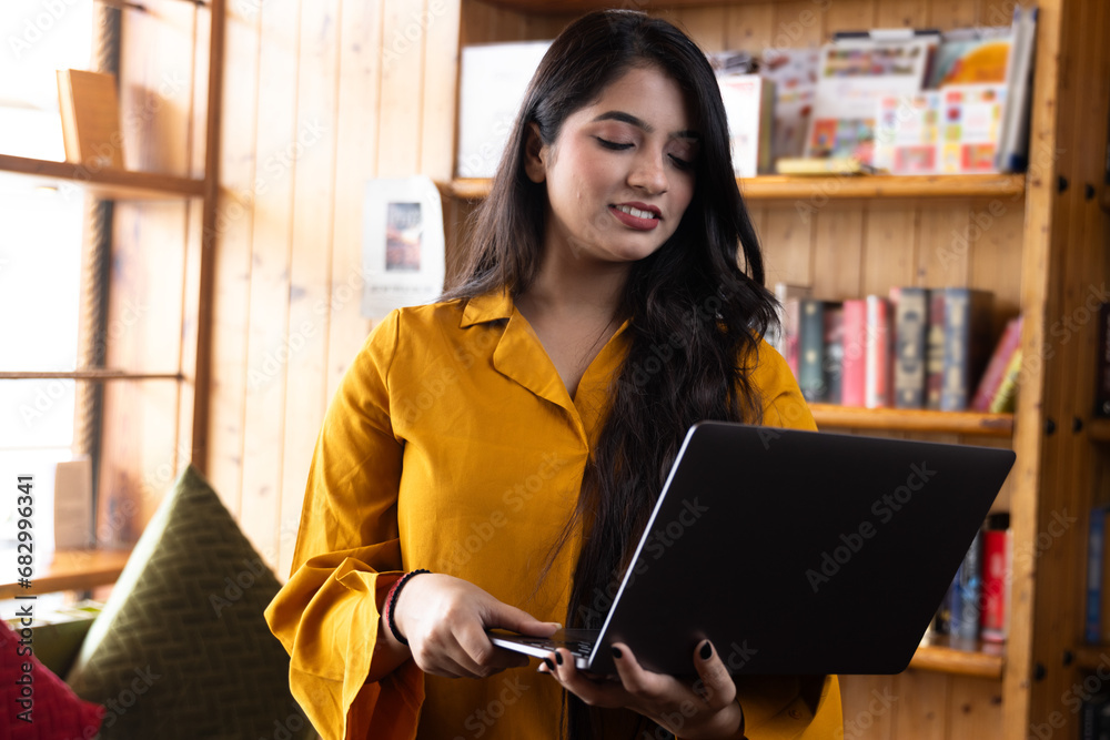 Beautiful young business woman girl student studying or explaining on video call on laptop in school or collage library or working in corporate office searching for information on internet or books Beautiful young business woman girl student studying or explaining on video call on laptop in school or collage library or working in corporate office searching for information on internet or books