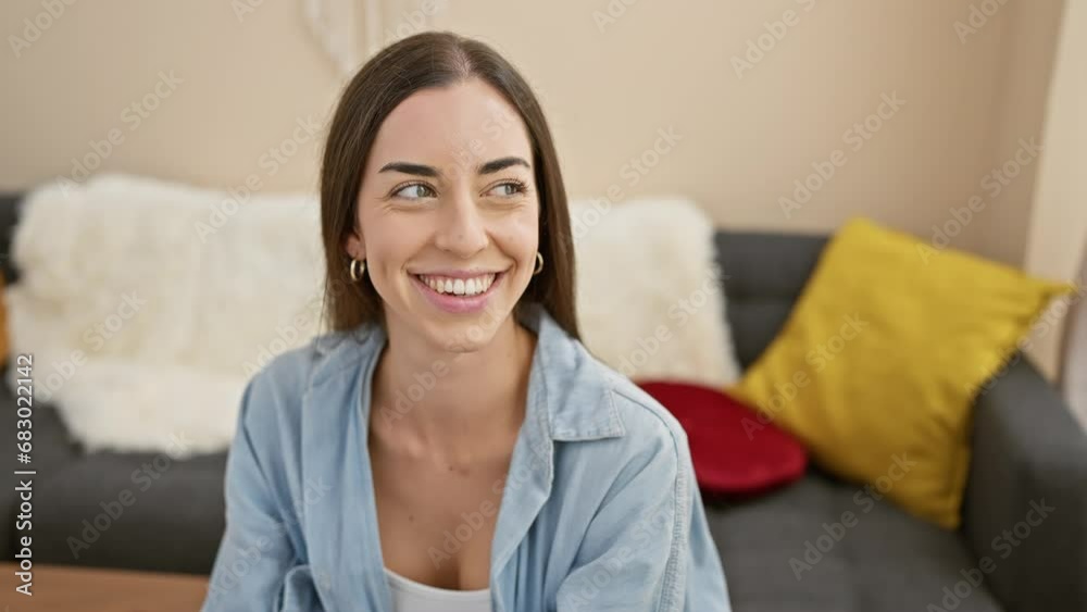 Heartwarming portrait of a young, beautiful hispanic woman, exuding confidence and joy, relaxing on her sofa at home, smiling off to the side Heartwarming portrait of a young, beautiful hispanic woman, exuding confidence and joy, relaxing on her sofa at home, smiling off to the side