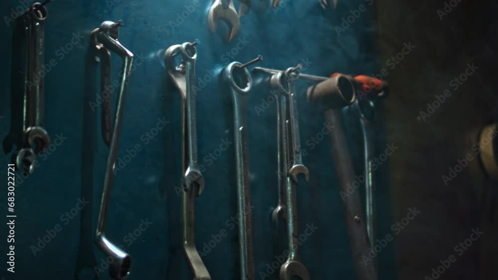 Men's hands hang tools on wall