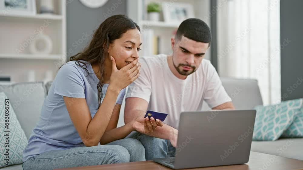 Beautiful couple, hugging and smiling, shopping online with credit card, celebrating investment wins on laptop, sitting together, confident in their love and financial victories, relaxing on home sofa Beautiful couple, hugging and smiling, shopping online with credit card, celebrating investment wins on laptop, sitting together, confident in their love and financial victories, relaxing on home sofa
