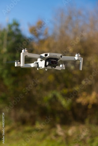 Drone with ND Filter hovering in the sky with autumn trees in background. photo
