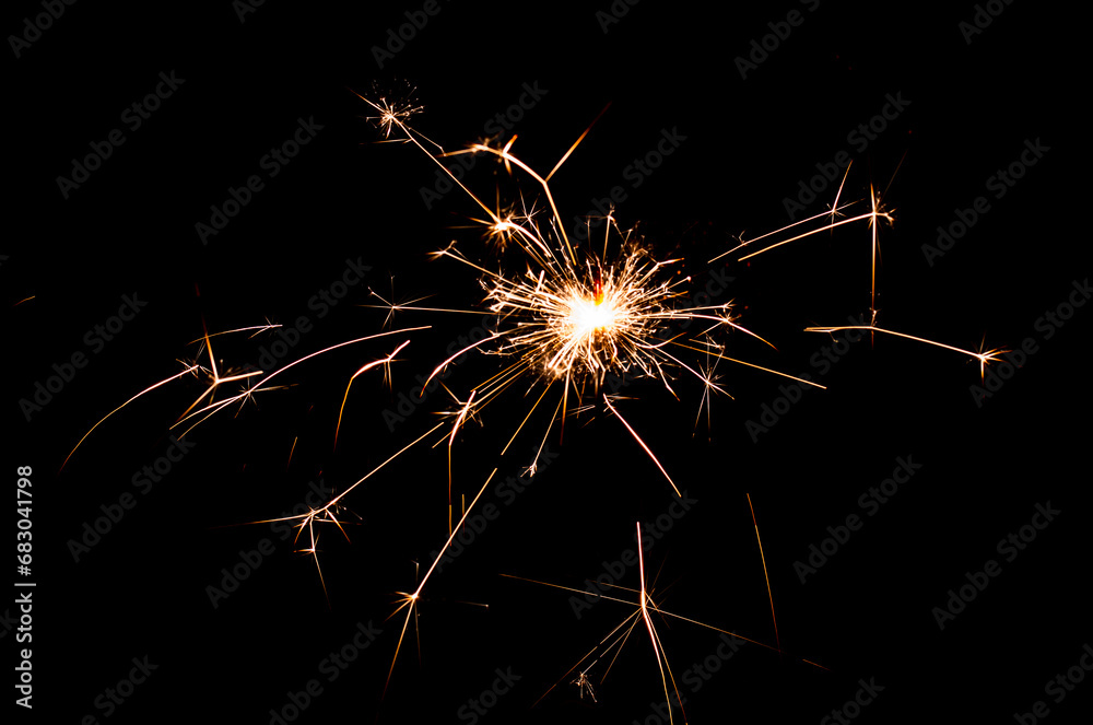 burning sparkler with flying sparks on a dark background