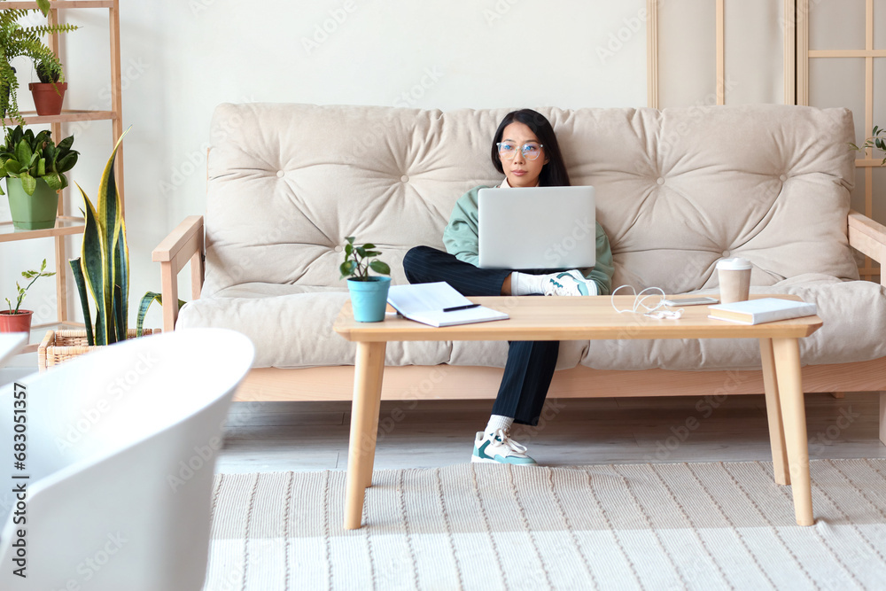 Young Asian woman working with laptop at home Young Asian woman working with laptop at home