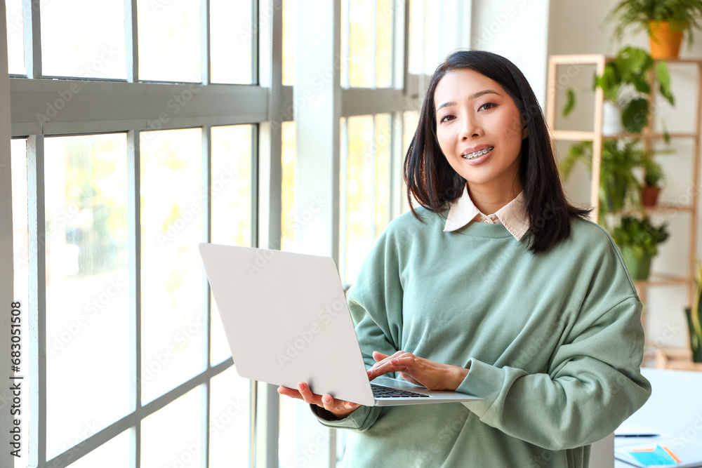 Young Asian woman working with laptop at home Young Asian woman working with laptop at home