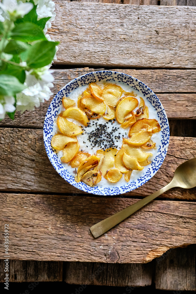 breakfast. Sweet rice milk porridge with apples and poppy seeds in the shape of a sunflower breakfast. Sweet rice milk porridge with apples and poppy seeds in the shape of a sunflower