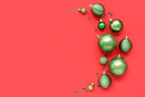 Composition with green Christmas balls with sparkles on red background