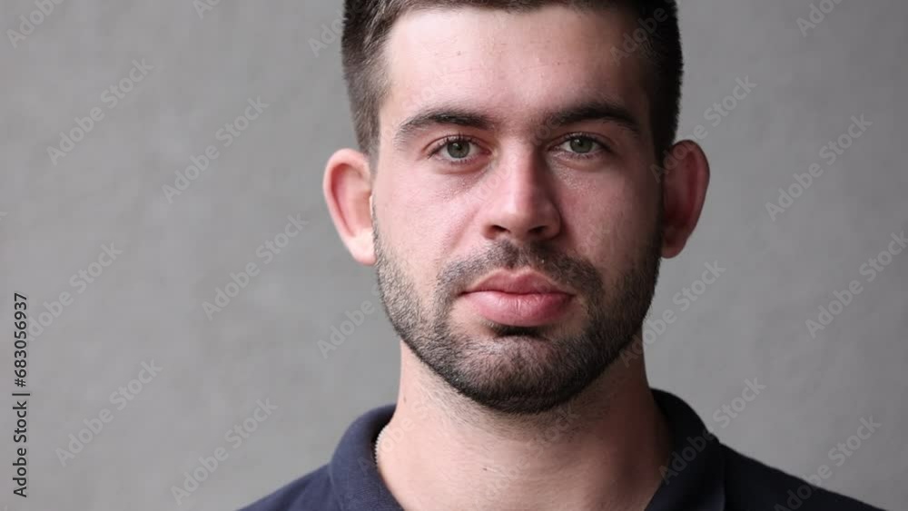 handsome brunette beard man in black t shirt blinking eyes and looking in camera. Guy with big lips and ears. handsome brunette beard man in black t shirt blinking eyes and looking in camera. Guy with big lips and ears.