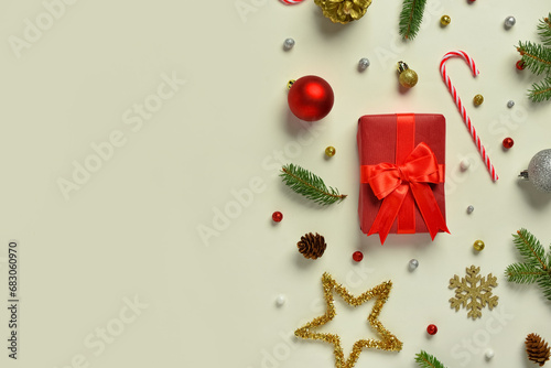 Beautiful Christmas composition with gift, fir-tree twigs, beads and space for text on green background