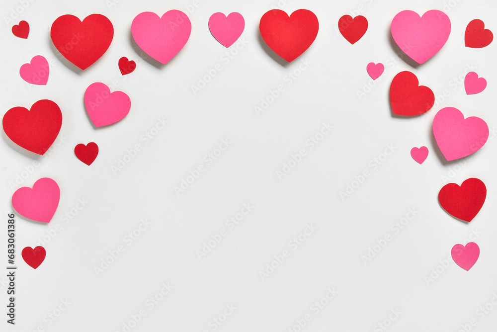 Romantic composition with red and pink paper hearts on white background. St. Valentine's Day.