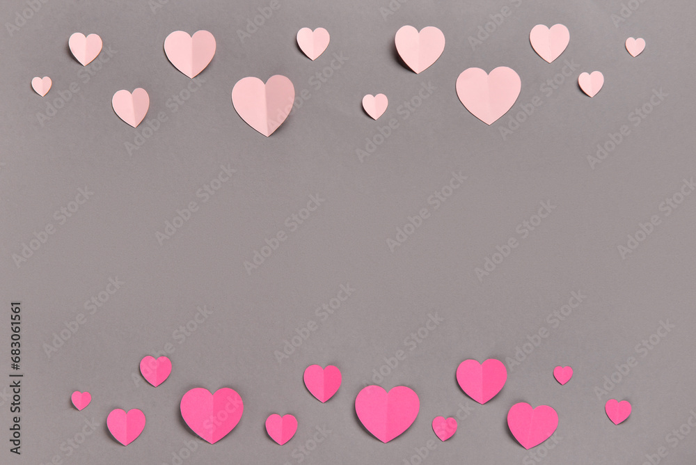 Romantic composition with pink paper hearts on grey background. St. Valentine's Day.