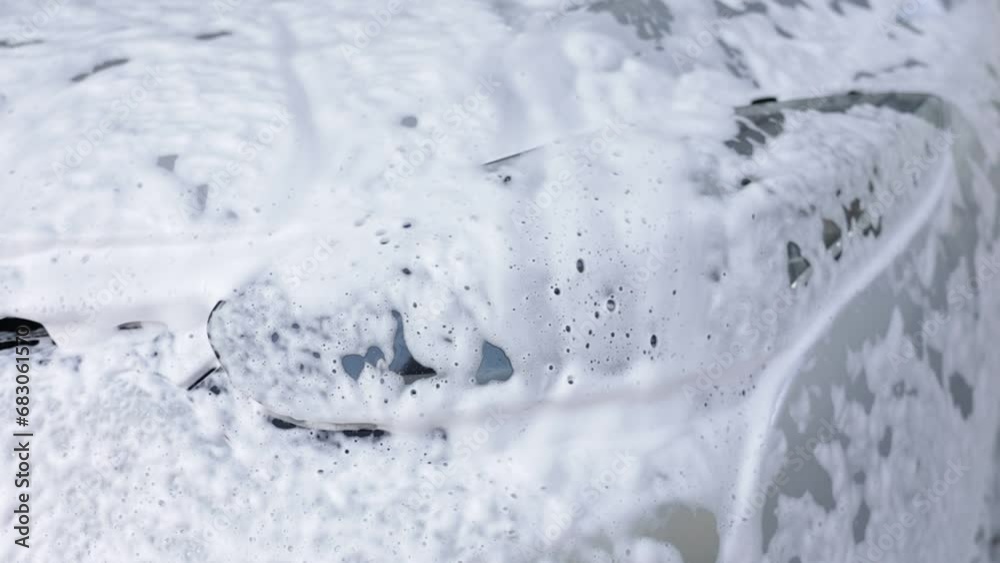 Car wash shampoo covering windshield at venhicle on touchless car wash service, camera rotate slow motion. Washing auto with foam self service and high pressure water. Auto industry and maintenance Car wash shampoo covering windshield at venhicle on touchless car wash service, camera rotate slow motion. Washing auto with foam self service and high pressure water. Auto industry and maintenance