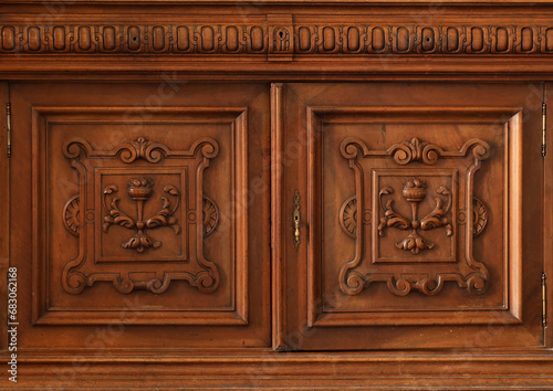 Old vintage wardrobe furniture with ornamental doors and retro colors of wooden surfaces close up