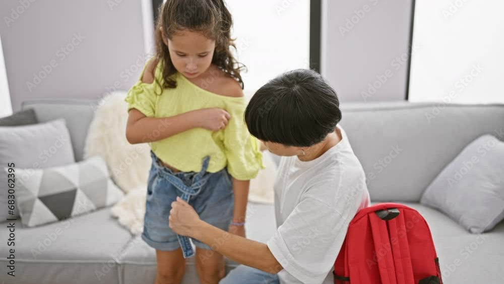Mother-daughter casual indoor time, two lovely ladies sitting on the living room sofa wearing cool clothes, the daughter, a student, with a study backpack at home, strengthening their relationship. Mother-daughter casual indoor time, two lovely ladies sitting on the living room sofa wearing cool clothes, the daughter, a student, with a study backpack at home, strengthening their relationship.