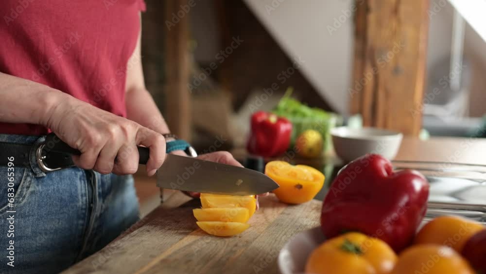 girl cutting and yellow tomato on a cartoon board cooking fresh vegetable salad, concept of healthy food at home girl cutting and yellow tomato on a cartoon board cooking fresh vegetable salad, concept of healthy food at home