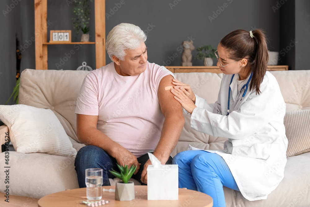 Nurse putting plaster on senior man after injection at home Nurse putting plaster on senior man after injection at home