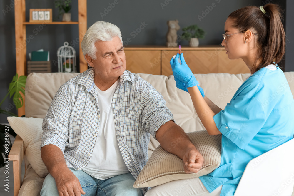 Nurse taking blood from senior man at home Nurse taking blood from senior man at home