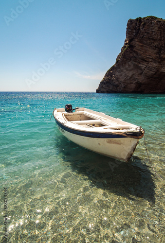 Boat on Chomi beach known as Paradise beach near Palaiokastritsa village on Corfu Island, Greece © Fotokon