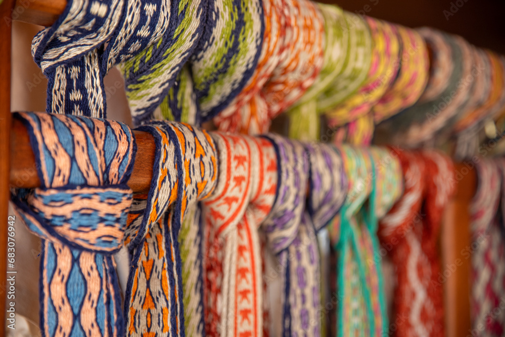 Many colorful belts with patterns. Folk art, handmade, Knitting of a traditional ethnic latvian folk belt - obrazy, fototapety, plakaty 