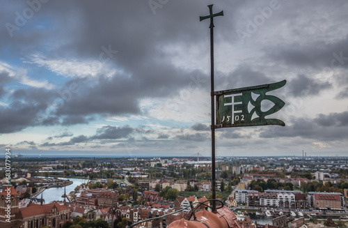 Polish ensign on the top of the tower of Saint Mary Church on Old Town of Gdansk city, Poland photo